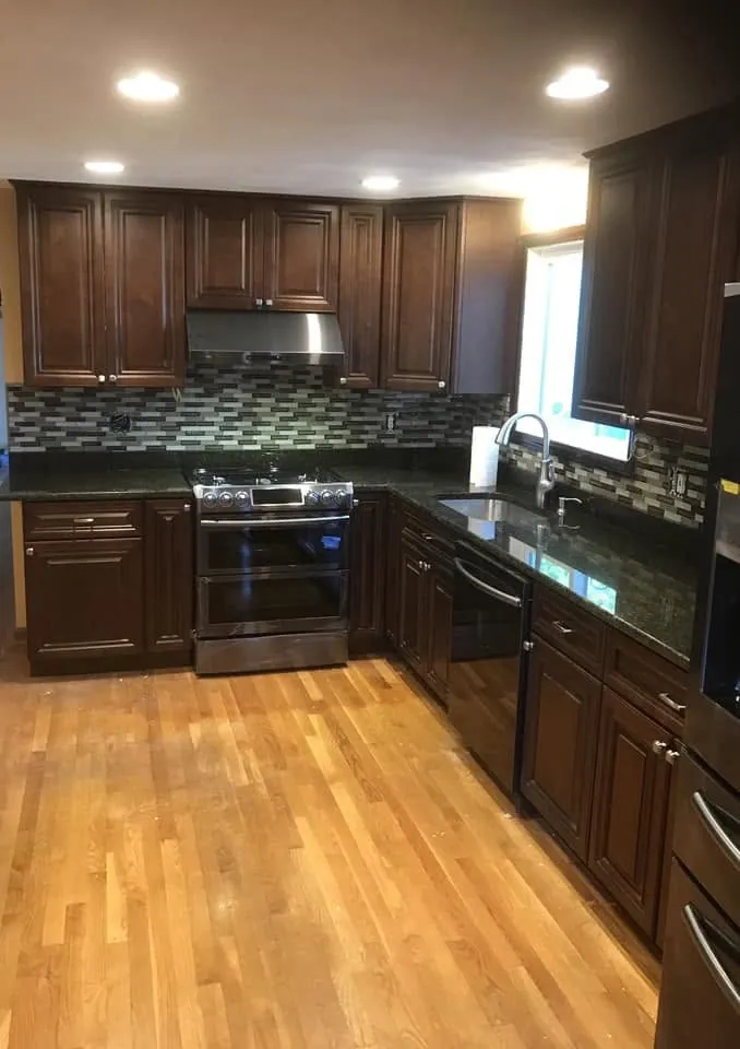 Remodeled kitchen with cherry cabinets, granite and a glass tile backsplash